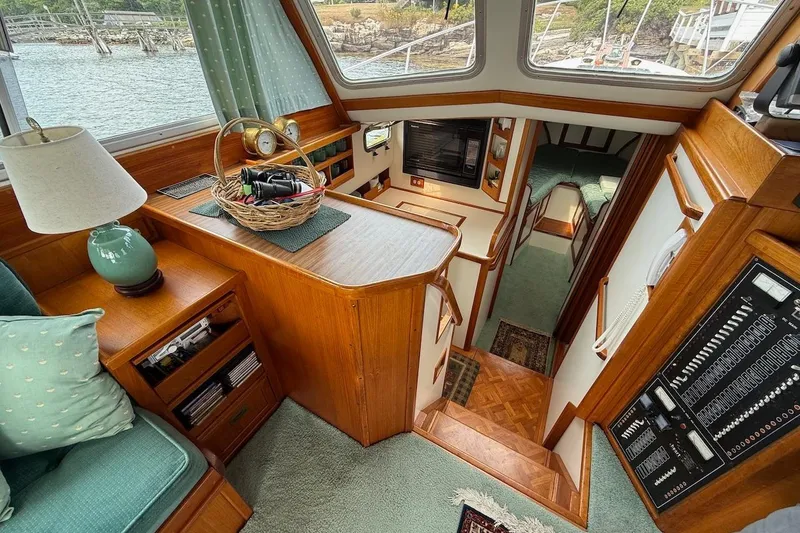 Slide: The Image of Interior of 1990 Nauset Flybridge Cruiser with wood accents and cozy seating area. - 9