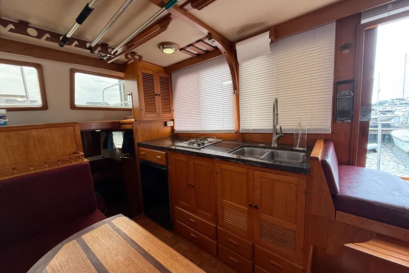 Slide: The Image of 1984 Chien Hwa 35 Trawler interior with wooden cabinetry, kitchen, and seating area. - 8