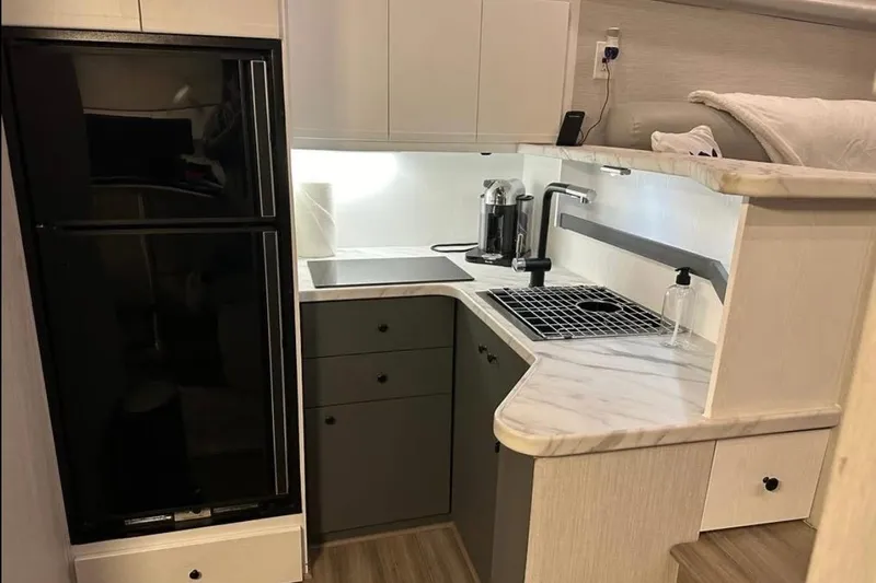 Slide: The Image of Compact kitchen in a 1995 Silverton 34 Convertible boat, featuring modern appliances and sleek design. - 11