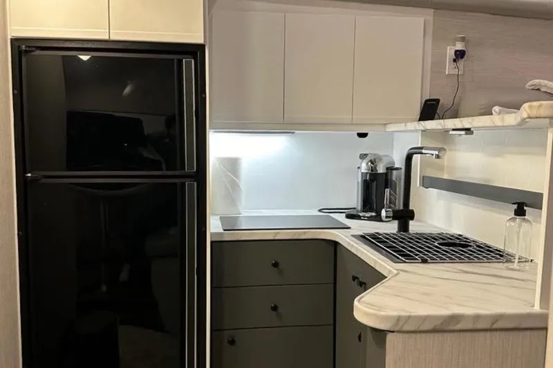 Slide: The Image of Modern kitchen interior in a 1995 Silverton 34 Convertible yacht, featuring sleek appliances and cabinetry. - 12