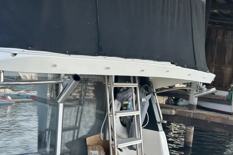 Slide: The Image of 1995 Silverton 34 Convertible boat with black canopy and dockside view. - 28