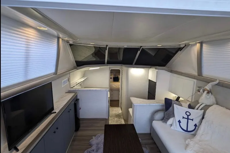 Slide: The Image of Interior of a 1995 Silverton 34 Convertible yacht, featuring modern decor and cozy seating. - 4