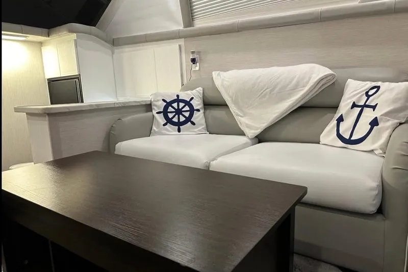 Slide: The Image of Interior of 1995 Silverton 34 Convertible with nautical-themed cushions on a sofa. - 7