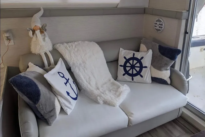 Slide: The Image of Cozy interior of 1995 Silverton 34 Convertible with nautical-themed pillows and plush decor. - 8
