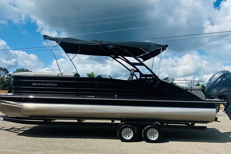 Slide: The Image of 2023 Bennington 25RSBA pontoon boat on trailer under cloudy sky. - 10