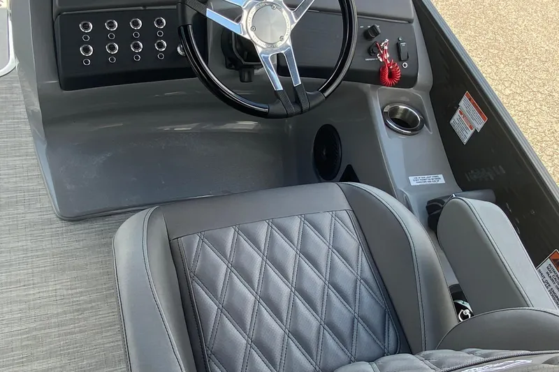 Slide: The Image of 2023 Bennington 25RSBA boat interior with steering wheel and quilted seat design. - 16