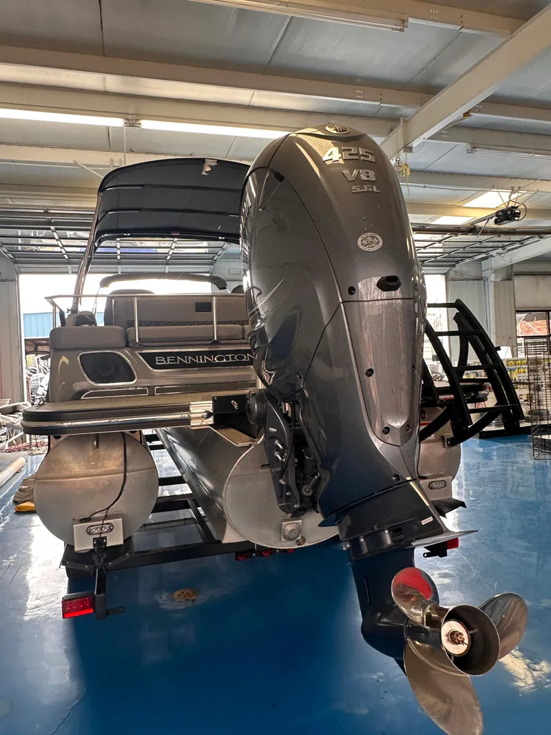 Slide: The Image of 2023 Bennington 25RSBA pontoon boat with powerful outboard motor in a showroom. - 4