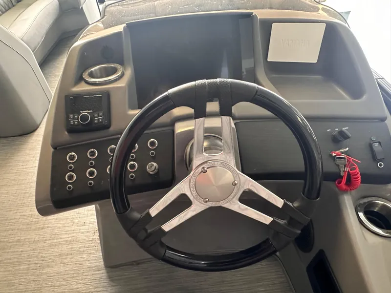 Slide: The Image of Steering console of 2023 Bennington 25RSBA boat with controls and cup holder. - 9