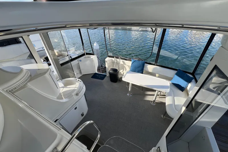 Slide: The Image of 2004 Carver 466 MY yacht interior with seating, table, and water view. - 16
