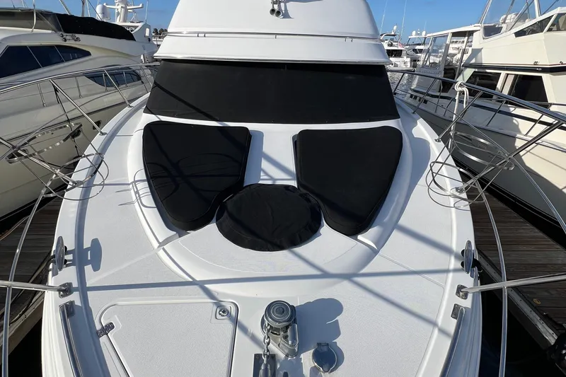 Slide: The Image of 2004 Carver 466 MY yacht deck with black sun pads, docked at marina. - 20