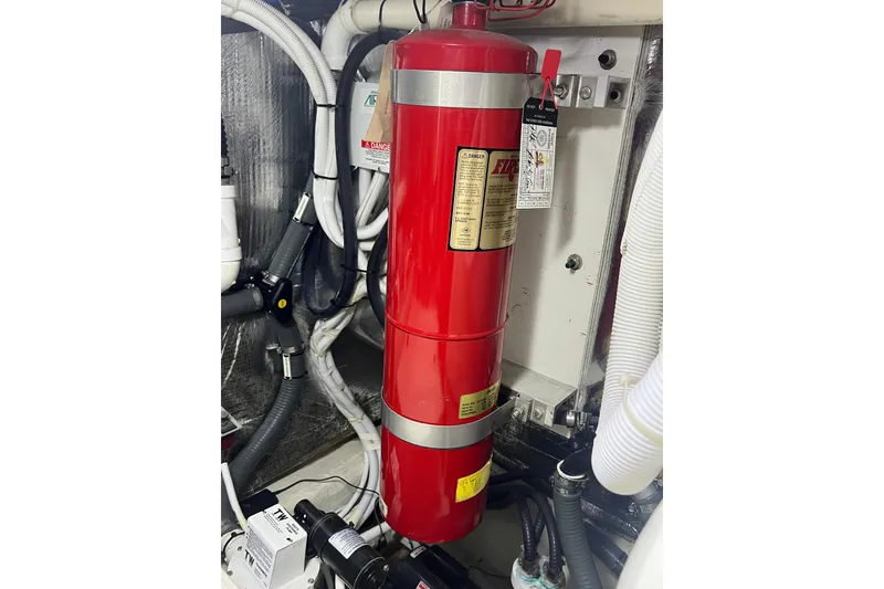 Slide: The Image of Engine room of 2004 Carver 466 MY with red fire extinguisher and hoses. - 52