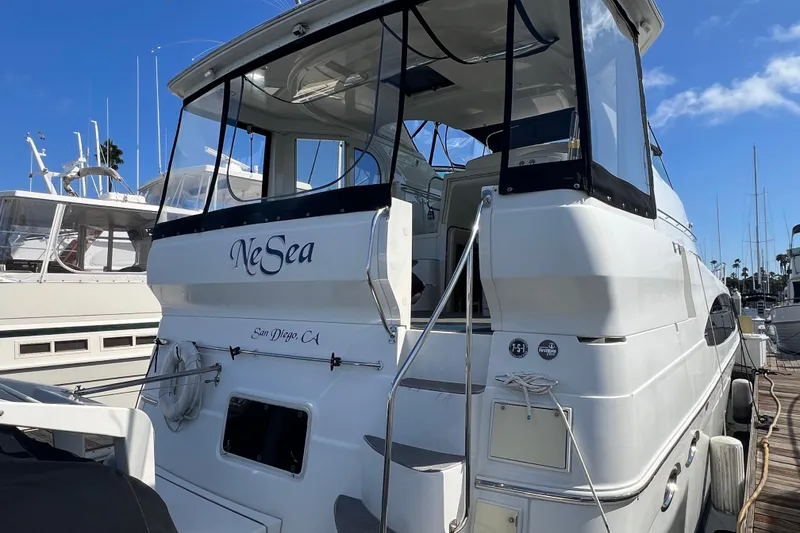 Slide: The Image of 2004 Carver 466 MY yacht docked in San Diego marina under clear blue sky. - 2