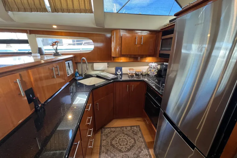 Slide: The Image of Luxurious kitchen interior of 2004 Carver 466 MY yacht with modern appliances and wood cabinetry. - 29