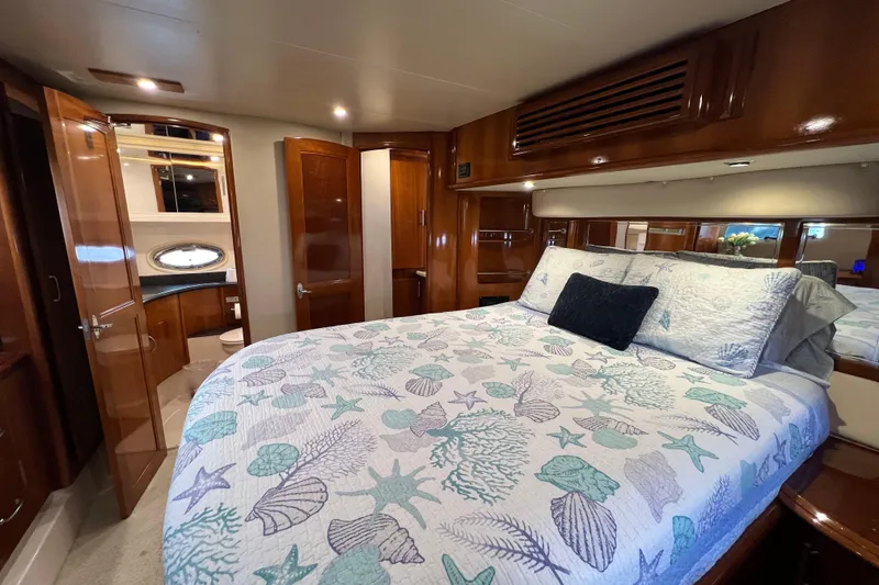 Slide: The Image of Luxurious 2004 Carver 466 MY yacht bedroom with elegant wood finishes and nautical-themed bedding. - 31