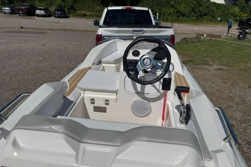 Slide: The Image of 2022 Zar Tender ZF0 boat interior with steering wheel, parked near a truck. - 10