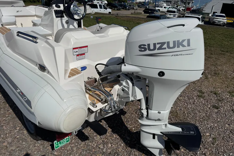 Slide: The Image of 2022 Zar Tender ZF0 boat with Suzuki outboard motor, parked on gravel. - 6