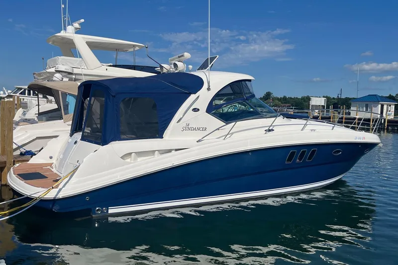 Slide: The Image of 2008 Sea Ray 380 Sundancer yacht docked in marina, featuring sleek blue and white design. - 1