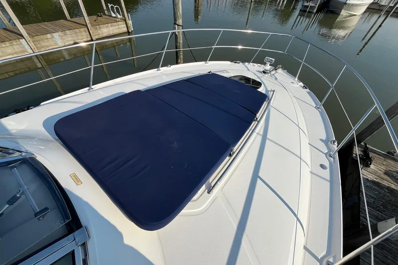 Slide: The Image of 2006 Sea Ray 380 Sundancer yacht with blue sunpad on deck, docked at marina. - 10