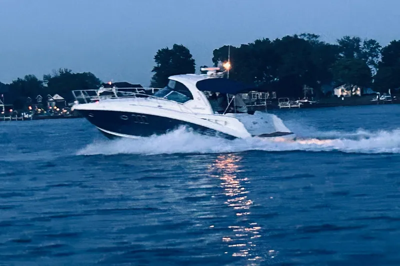 Slide: The Image of 2006 Sea Ray 380 Sundancer cruising on a serene lake at dusk. - 2