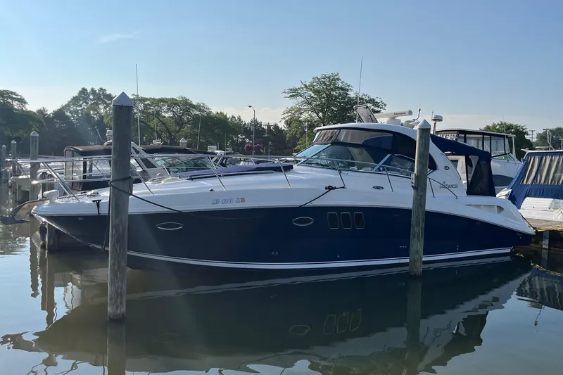 Slide: The Image of 2006 Sea Ray 380 Sundancer yacht docked in a marina, reflecting on calm water. - 3