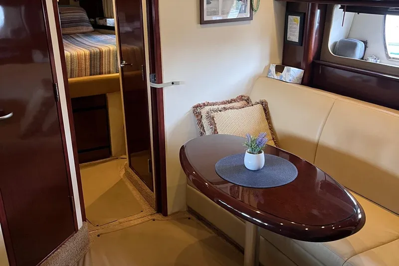Slide: The Image of Interior of 2008 Sea Ray 38 Sundancer with beige leather seating and warm lighting. - 35