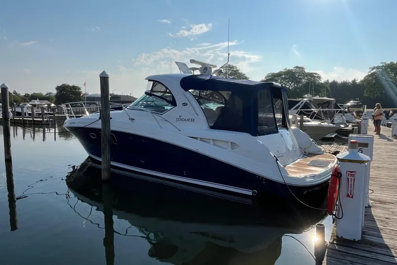 Slide: The Image of 2006 Sea Ray 380 Sundancer docked at a marina under a clear blue sky. - 5