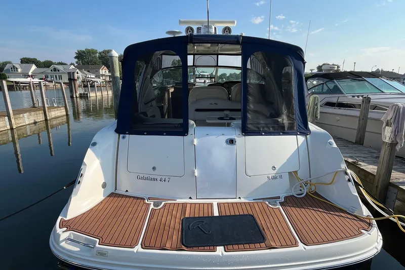 Slide: The Image of 2006 Sea Ray 380 Sundancer docked at marina, rear view with blue canopy. - 6