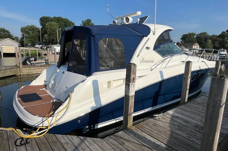 Slide: The Image of 2006 Sea Ray 380 Sundancer docked at a marina, featuring a sleek blue and white design. - 7