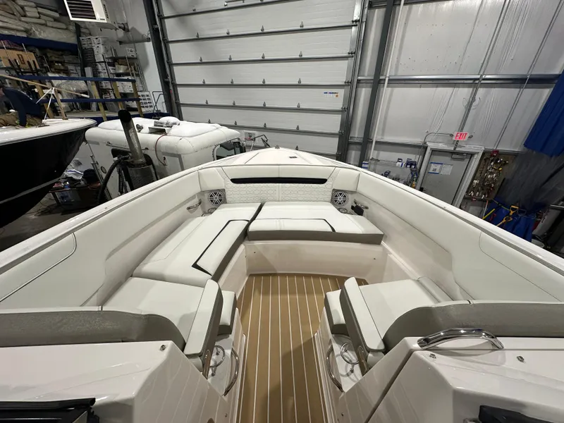 Slide: The Image of 2024 Tiara Yachts 34 LX interior with white seating and wood flooring in a garage. - 28
