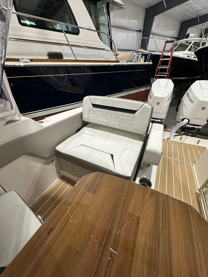 Slide: The Image of 2024 Tiara Yachts 34 LX interior with seating and wooden table in a showroom. - 5