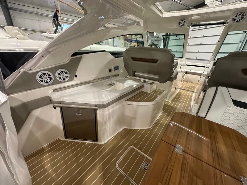 Slide: The Image of 2024 Tiara Yachts 34 LX interior with sleek design, featuring a kitchenette and seating area. - 8
