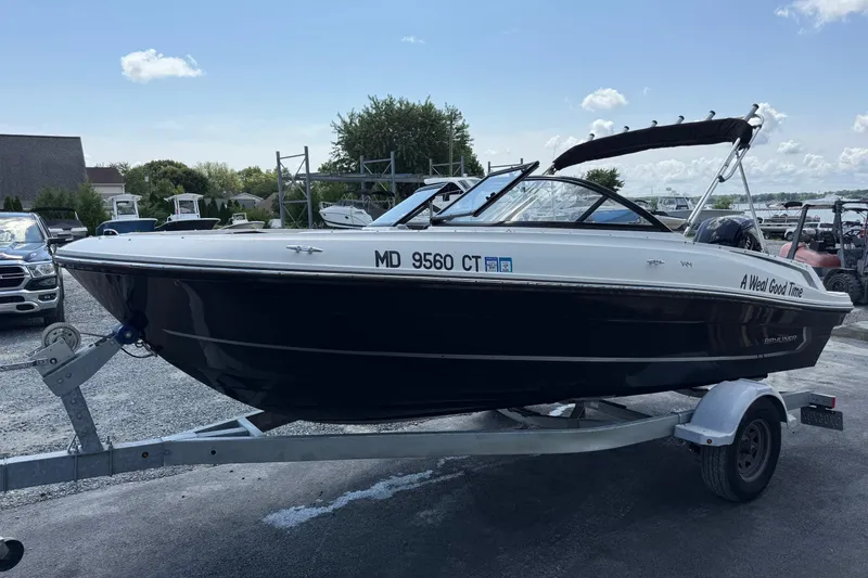 Slide: The Image of 2022 Bayliner VR4 Bowrider OB on trailer, parked outdoors under a clear sky. - 1