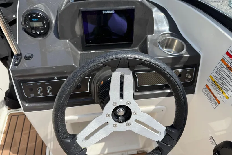 Slide: The Image of 2022 Bayliner VR4 Bowrider OB dashboard with steering wheel and Simrad display. - 11