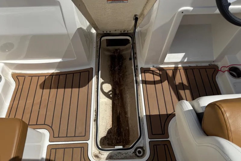 Slide: The Image of 2022 Bayliner VR4 Bowrider OB interior with brown flooring and storage compartment. - 13