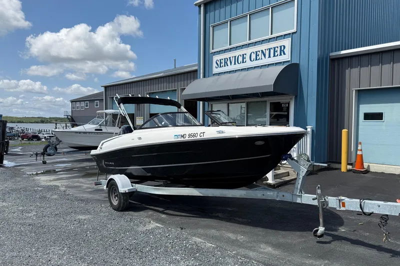 Slide: The Image of 2022 Bayliner VR4 Bowrider OB on trailer outside service center, under blue sky. - 4