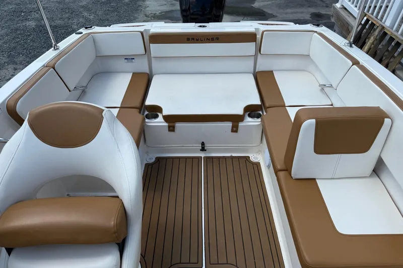 Slide: The Image of 2022 Bayliner VR4 Bowrider OB interior with tan and white seating, wood-style flooring. - 7