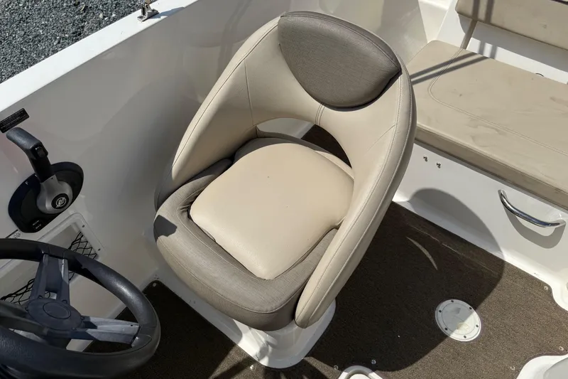 Slide: The Image of 2016 Bayliner VR5 Bowrider interior with beige captain's chair and steering wheel. - 11