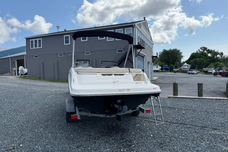 Slide: The Image of 2016 Bayliner VR5 Bowrider boat on trailer near marina building under blue sky. - 2