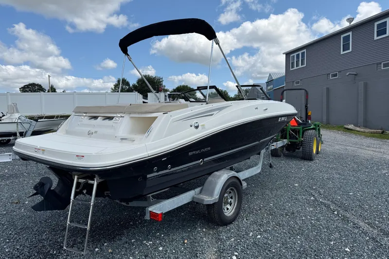 Slide: The Image of 2016 Bayliner VR5 Bowrider on trailer, parked outdoors under a partly cloudy sky. - 3