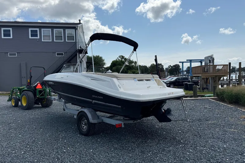 Slide: The Image of 2016 Bayliner VR5 Bowrider on trailer, parked near a building and tractor. - 4