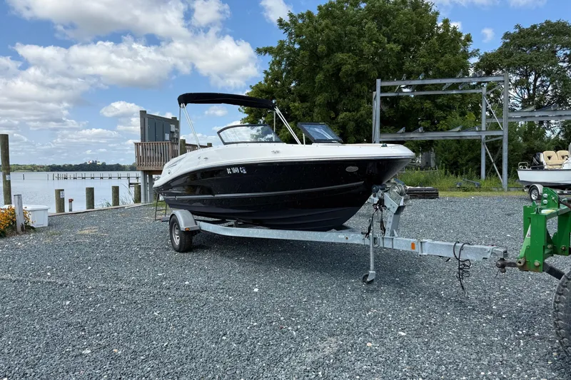 Slide: The Image of 2016 Bayliner VR5 Bowrider on trailer, parked near waterfront under blue sky. - 5