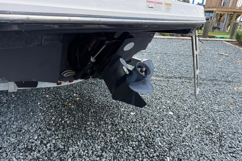 Slide: The Image of 2016 Bayliner VR5 Bowrider boat propeller and stern on gravel surface. - 7