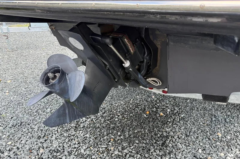 Slide: The Image of 2016 Bayliner VR5 Bowrider boat propeller and outdrive on gravel surface. - 8