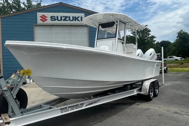The Image of 2026 Pair Customs 24 Center Console DV boat on trailer at Suzuki dealership. - 0