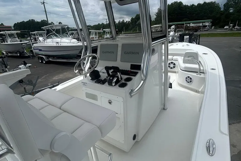Slide: The Image of 2026 Pair Customs 24 Center Console DV boat with Garmin electronics, docked in a marina. - 2