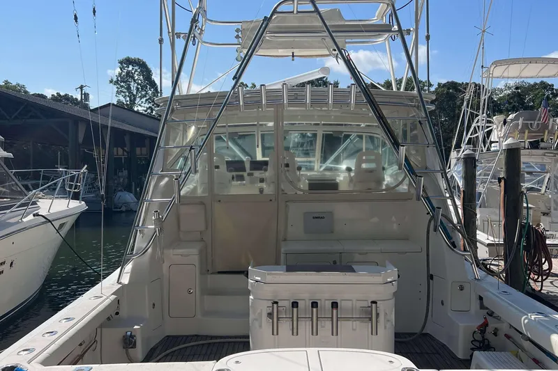 Slide: The Image of 2007 Henriques 42 Express boat docked, showcasing spacious cockpit and fishing equipment. - 2