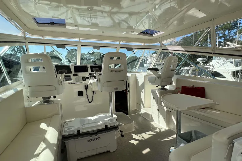 Slide: The Image of 2007 Henriques 42 Express boat interior with white seating, table, and red cushions. - 28