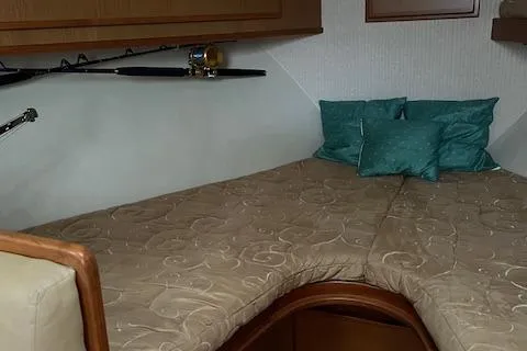 Slide: The Image of 2007 Henriques 42 Express cabin interior with bunk beds and fishing rods. - 42