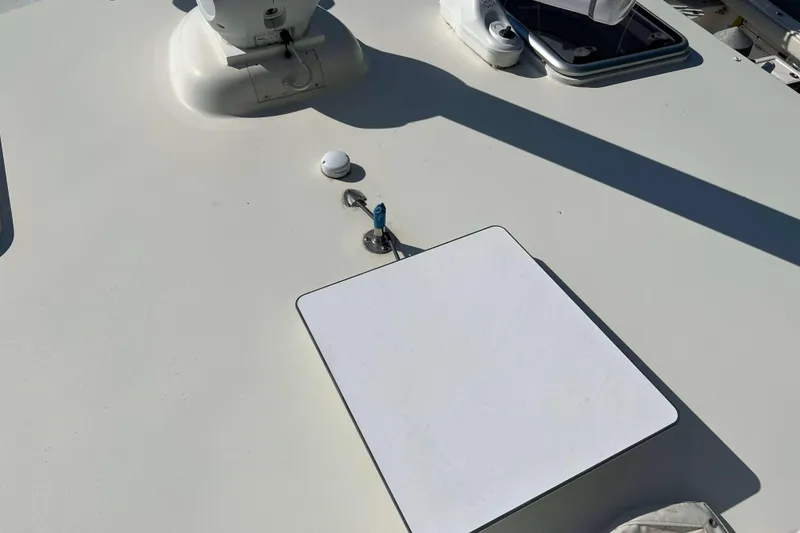 Slide: The Image of 2007 Henriques 42 Express boat seating area with white upholstery and metal frame. - 75