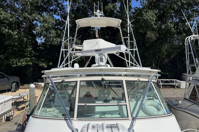 Slide: The Image of 2007 Henriques 42 Express boat with Simrad radar, docked near trees. - 80